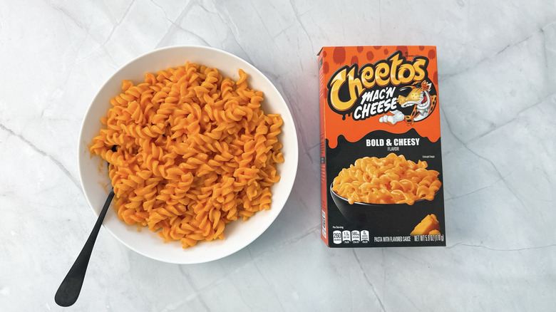 bowl of macaroni and cheese and box from cheeto's