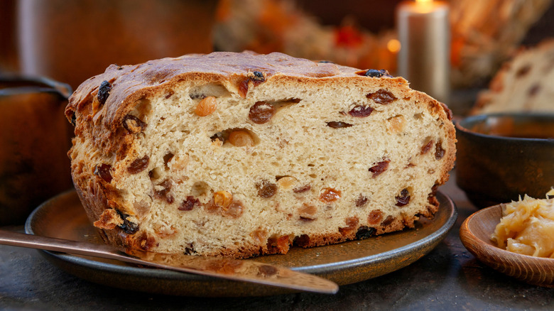 Sliced loaf of Irish barmbrack fruit bread on a plate with a butter knife