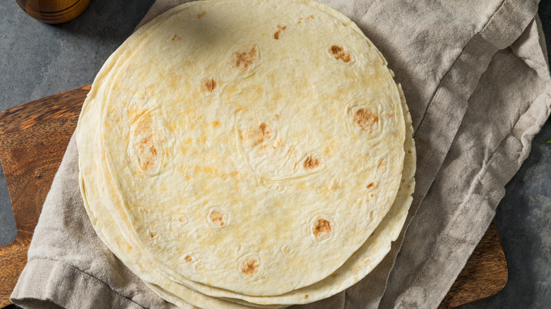 Pile of flour tortillas on a gray linen cloth