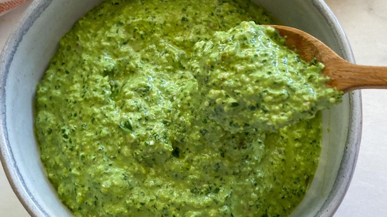 pesto in bowl with wooden spoon