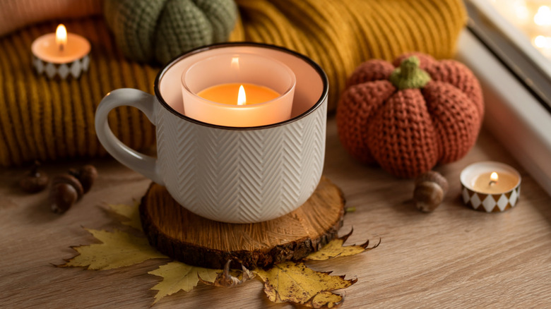 A candle in a white mug