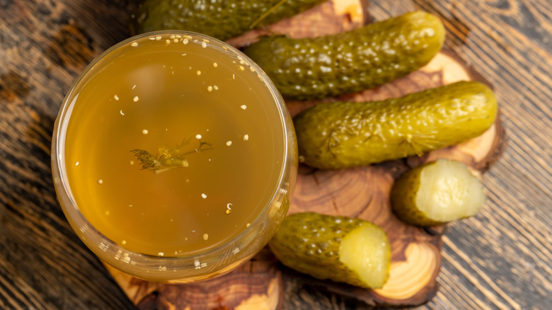 glass of pickle juice and pickles