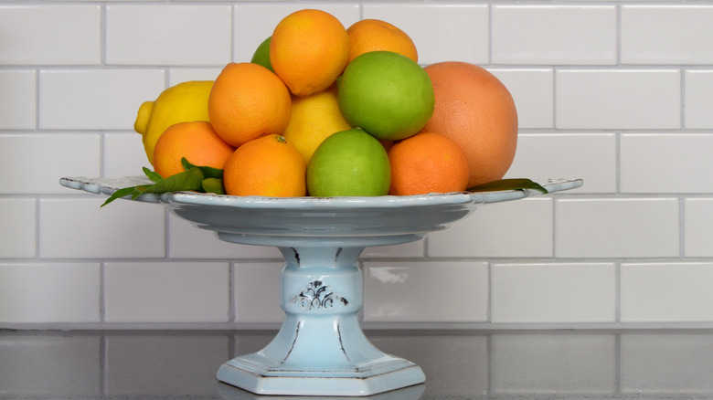 Citrus fruits in pedestal bowl on counter