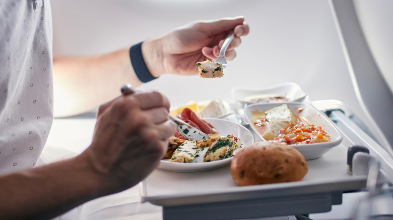Man eating meal in airplane