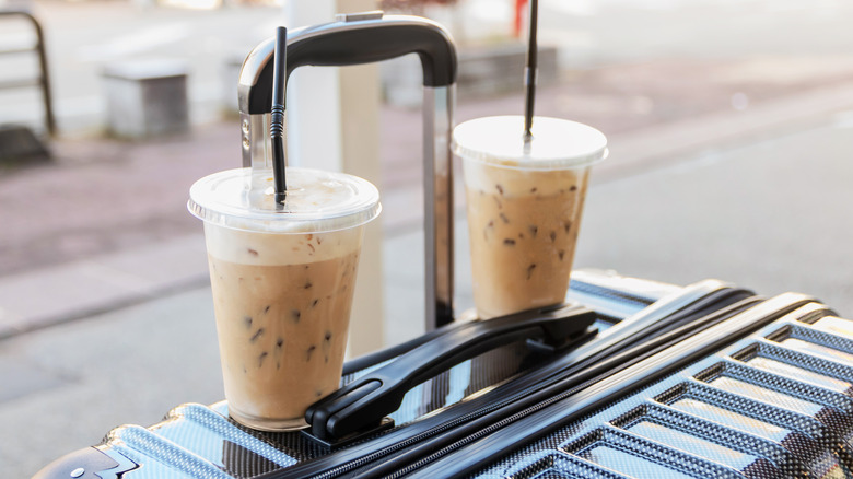 cups of coffee sitting on suitcase
