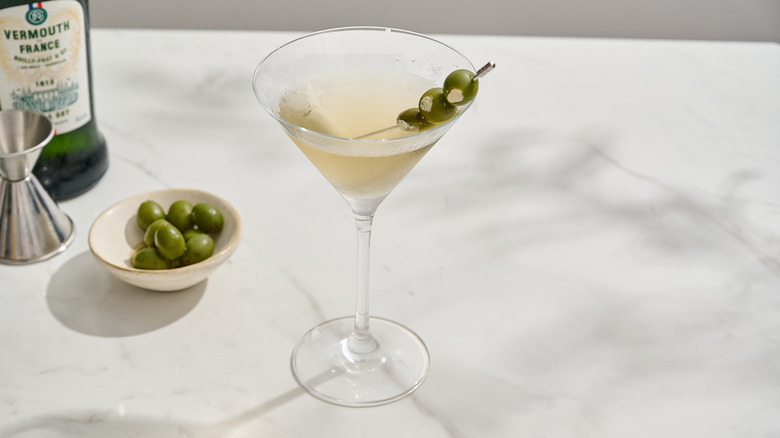 garnishing cocktail with prepared olives