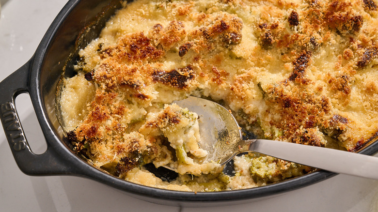 spoon scooping broccoli au gratin out of dish