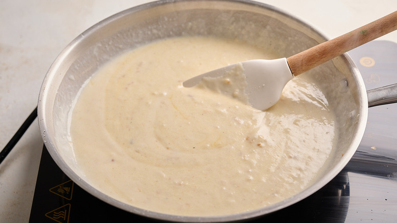 stirring cheese sauce with a spatula