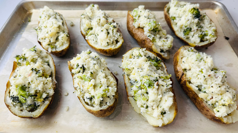 Broccoli cheddar twice baked potatoes on baking sheet