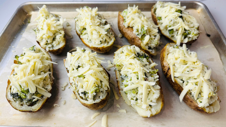 Twice baked potatoes topped with shredded cheese