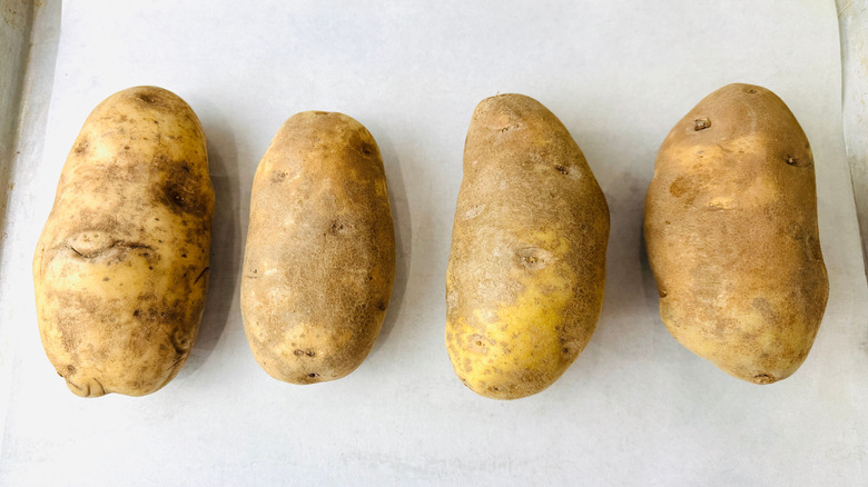 Russet potatoes on baking sheet