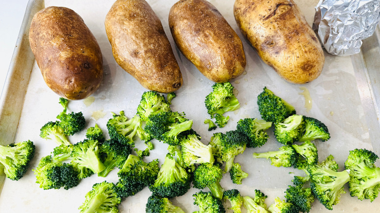 Russet potatoes and broccoli on baking sheet