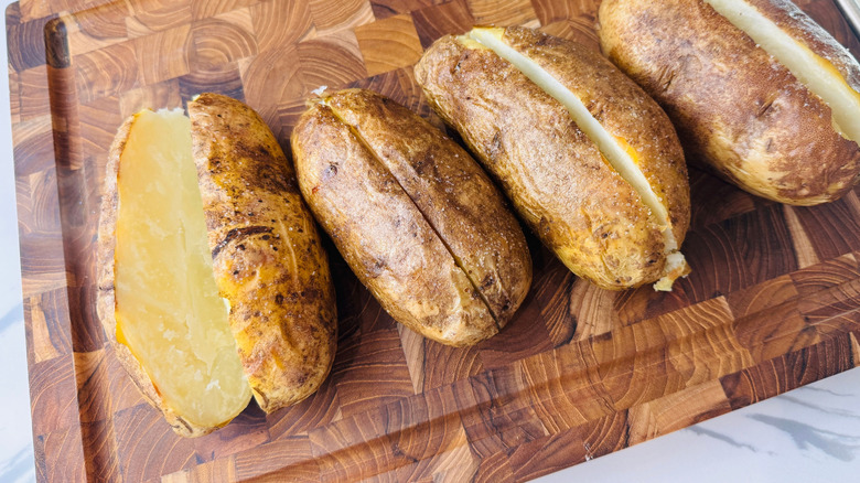 Sliced potatoes on wooden board