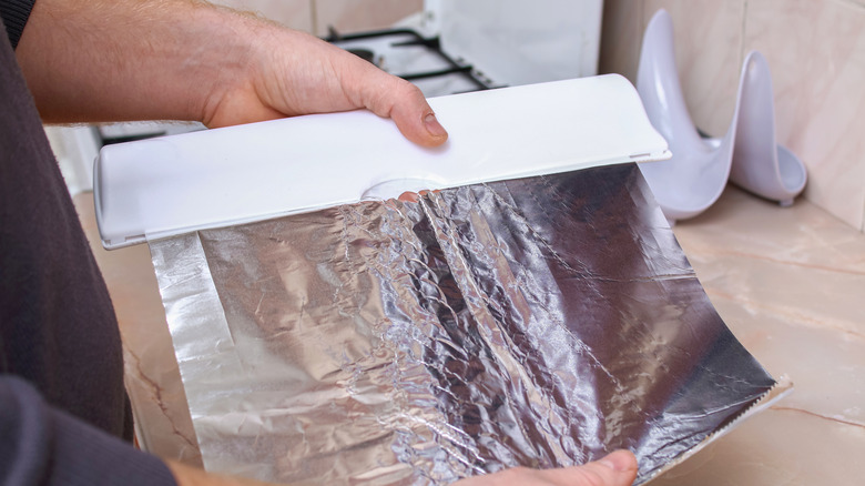 man pulling sheet of foil
