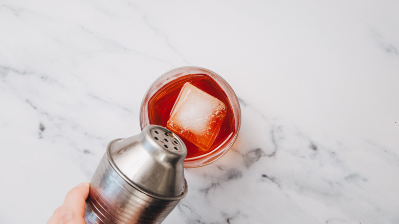 Pouring cocktail over ice