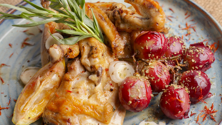 Plate with roasted chicken and roasted grapes