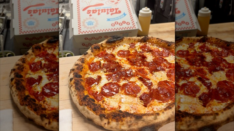 Pepperoni pizza on a wooden countertop in front of a Talula's pizza box