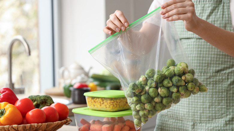 Woman closing a freezer bag of Brussels sprouts