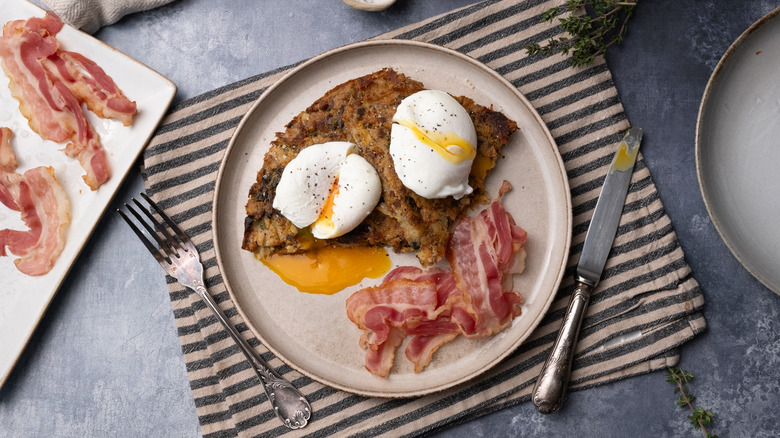 bubble and squeak with poached eggs and bacon on plate