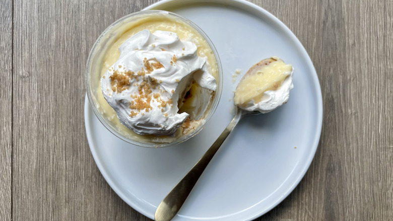 Coconut cream pie cup with a spoonful pulled out on a plate
