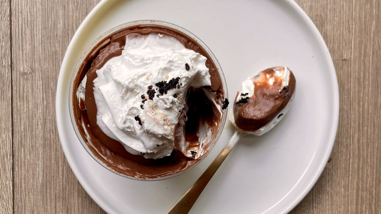 Chocolate pudding cup with a spoonful pulled out on a plate