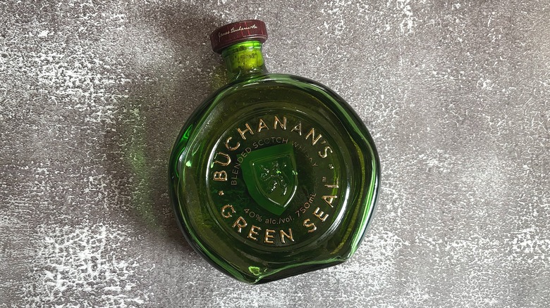 Green bottle of Buchanan's Green Seal laying down on black background