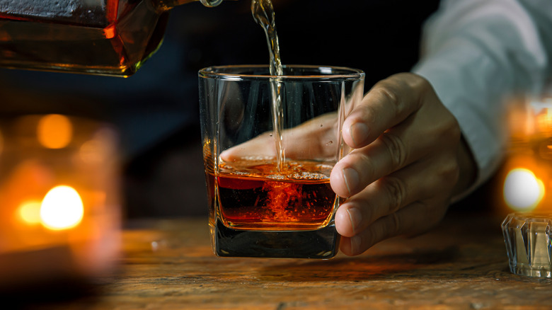 hand pouring bourbon