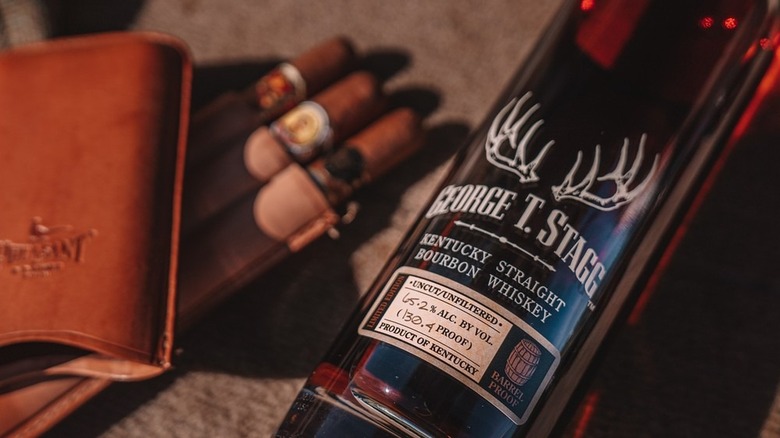 Bottle of Buffalo Trace George T. Stagg laying down on table next to cigars