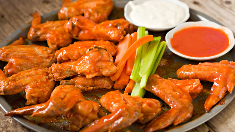 Buffalo wings on a platter with sauces