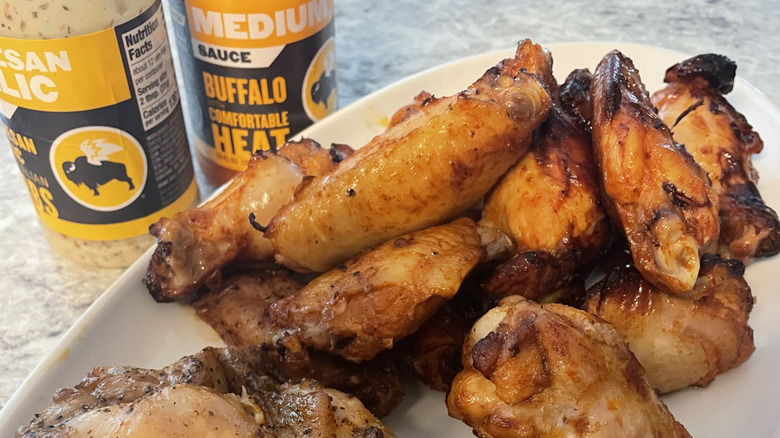 plate of fried chicken wings in front of buffalo wild wings sauces