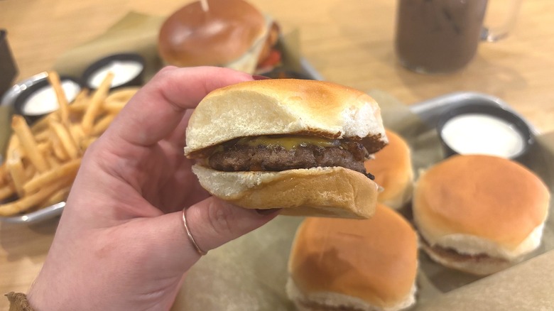 Hand holding King's Hawaiian Cheeseburger Slider from Buffalo Wild Wings