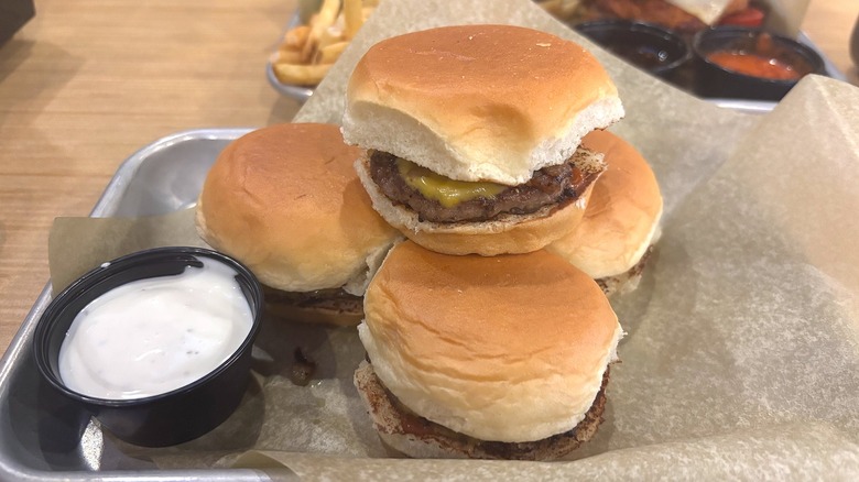 Four King's Hawaiian Cheeseburger Sliders next to side of ranch on tray at Buffalo Wild Wings