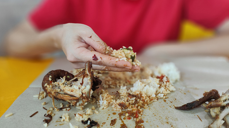 Woman eating with hands at restaurant
