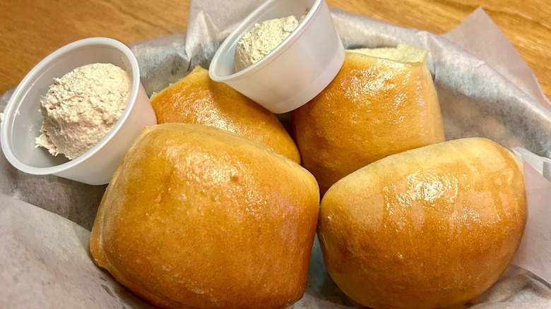 Four dresh bread rolls from Texas Roadhouse, alongside whipped cinnamon butter