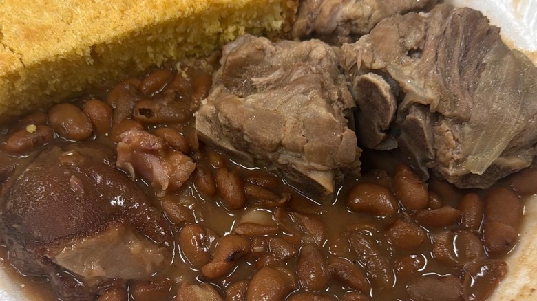 closeup of pot roast with pinto beans and side of corn bread