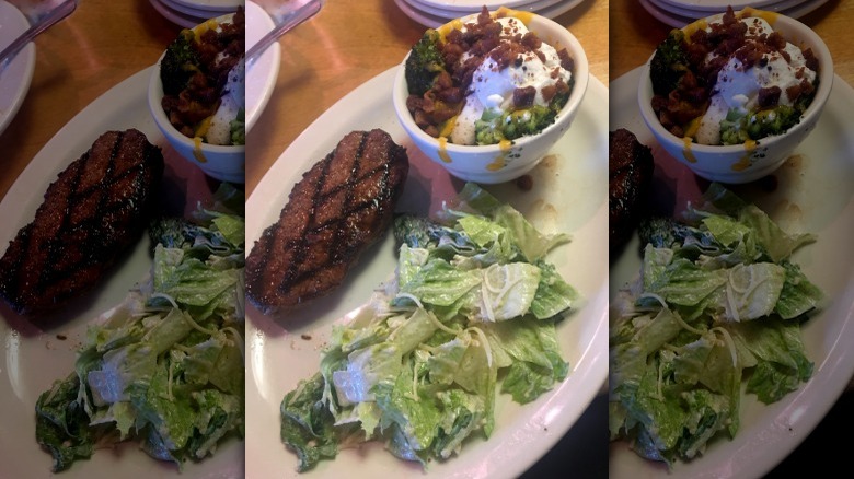 Plate with steak, salad, and loaded broccoli from Texas Roadhouse