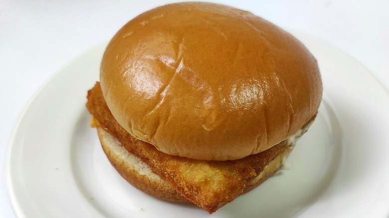 a McDonald's Filet-O-Fish sandwich on a white plate against a white background