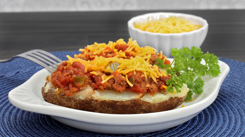 Chili stuffed baked potato on a plate