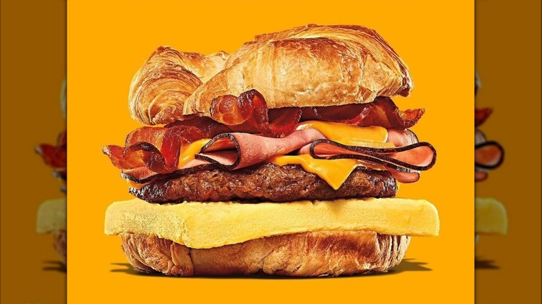 Burger King Fully Loaded Croissan'wich breakfast sandwich on orange background
