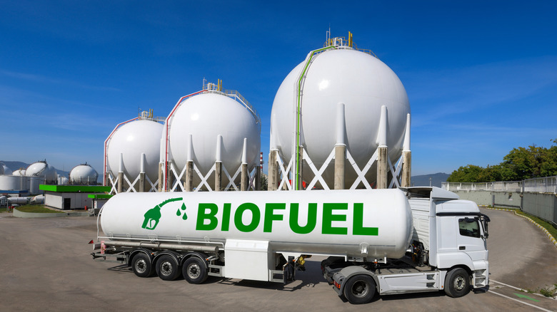 A massive tanker truck labeled biofuel in front of some large storage tanks