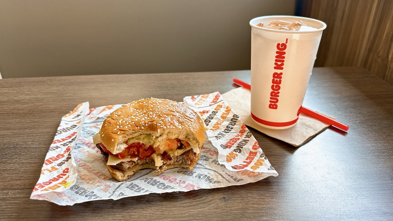 half-eaten Burger King Peppercorn BLT Whopper on wrapper