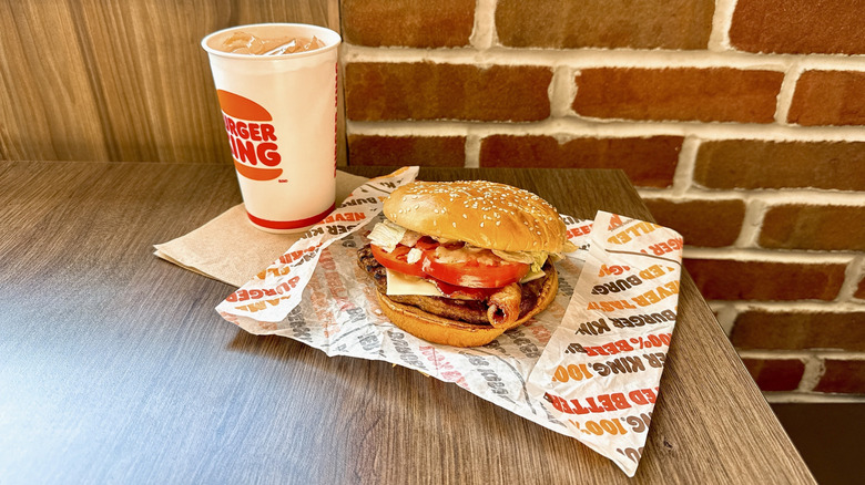 Burger King Peppercorn BLT Whopper unwrapped next to drink