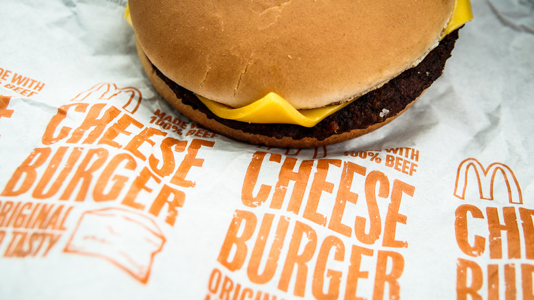 McDonald's cheeseburger sitting beside wrapper