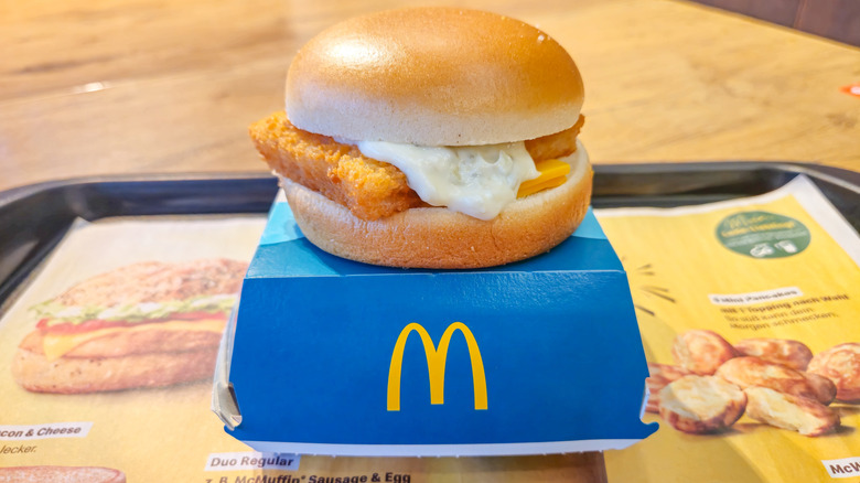 A McDonald's Filet-o-Fish resting on top of its box on a tray.