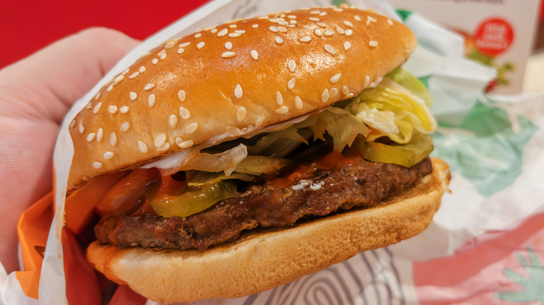 Hand holding a Whopper from Burger King