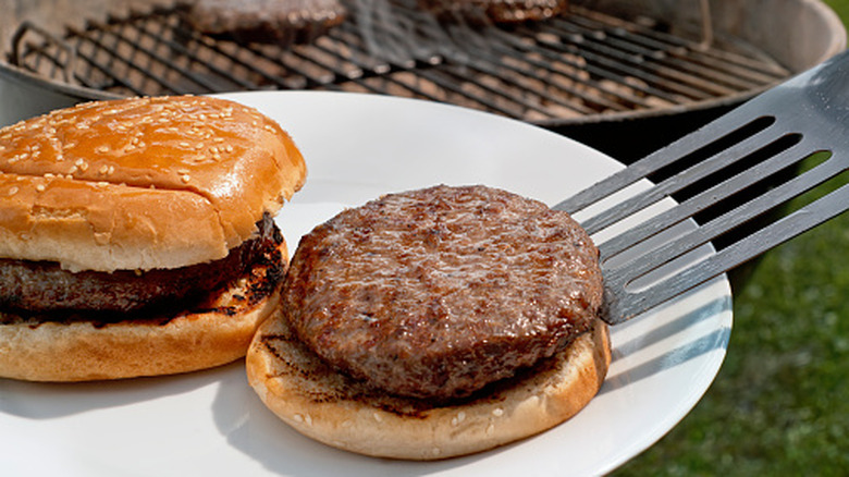 A freshly grilled burger being plated