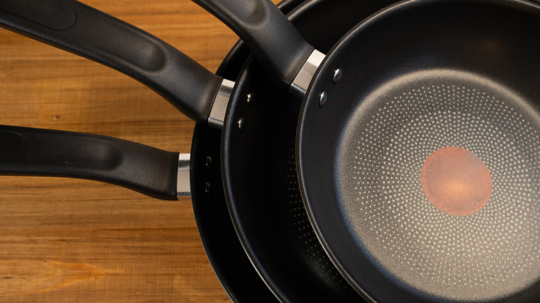 Stacked nonstick pans with plastic handles