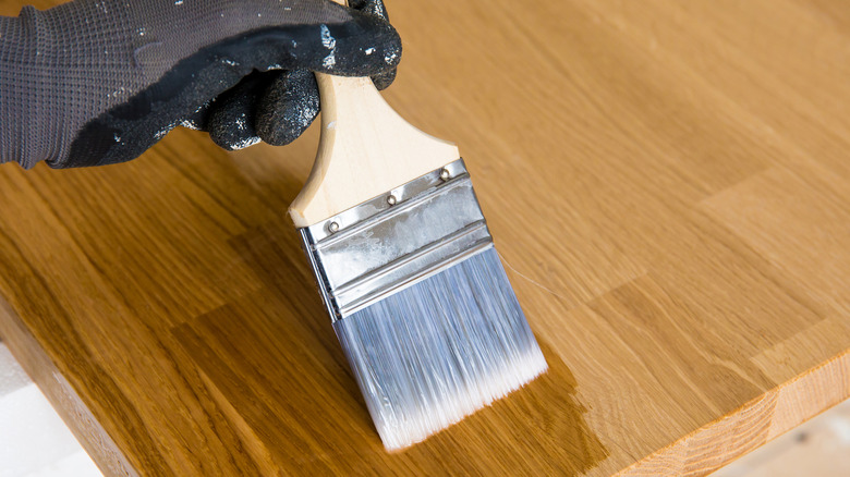person applying oil to butcher block