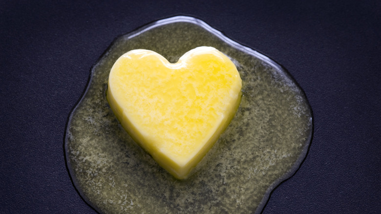 heart shaped butter melting on dark background