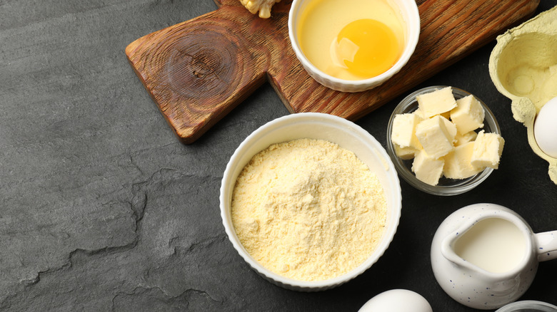 Overhead view of cornbread dry ingredients, butter, eggs, and milk on a table